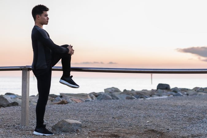 Asian man stretching legs during outdoor workout