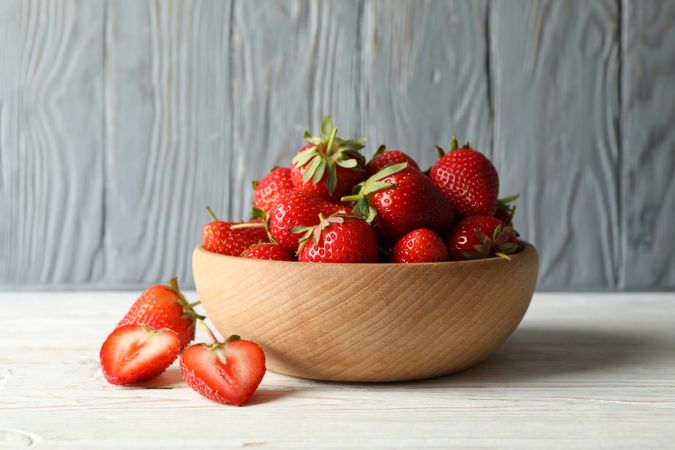 Bowl with tasty strawberry on wooden table. Summer berry