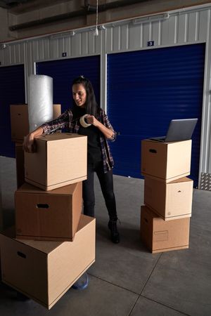 Woman taping box with scotch tape