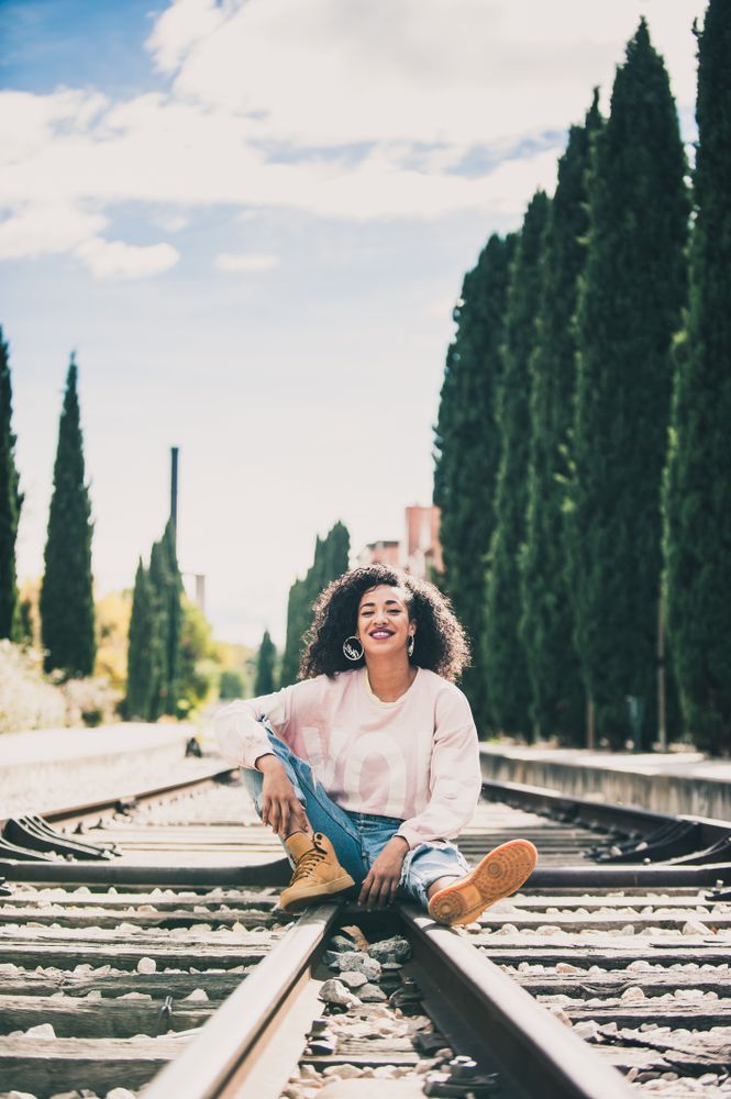woman laughing in the tracks of a train