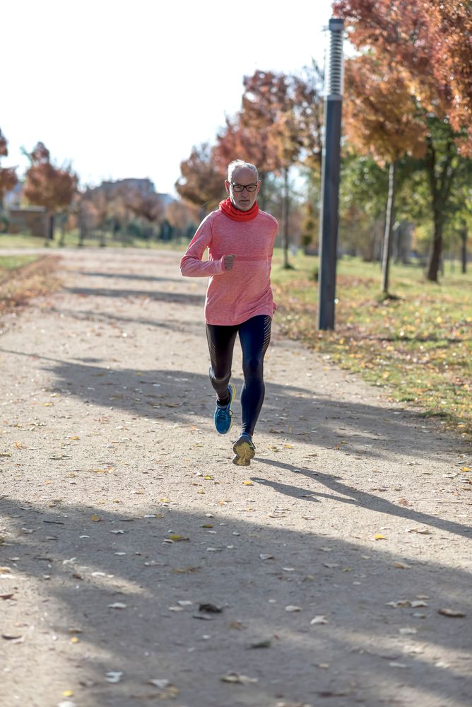 Mature man jogging outside in park