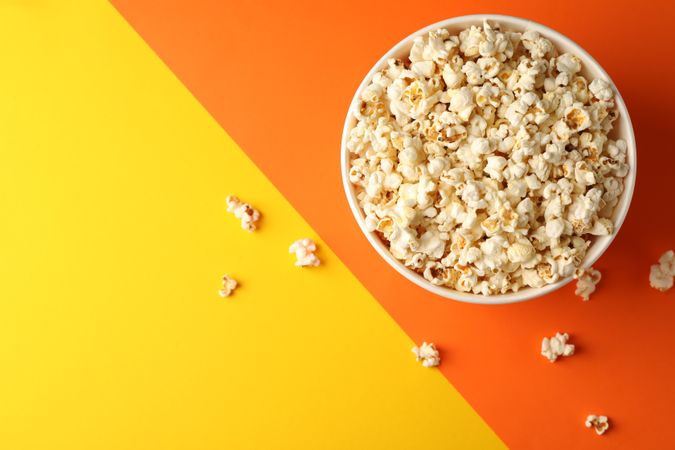Flat lay composition. Bucket with popcorn on two tone background