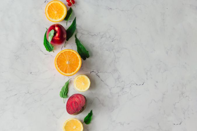 Fruits, vegetable and herbs on bright marble table background