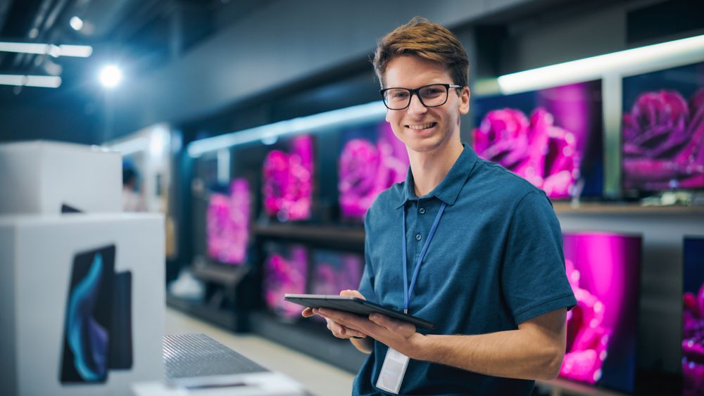Portrait of an Organized Assistant in Home Electronics Store Optimizing Workflows with Tablet Computer.