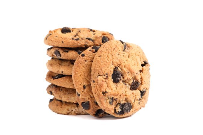 Stack of tasty chocolate chip cookies on plain background
