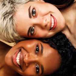 Two smiling friends lying sideways
