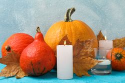Composition with pumpkins and candles on wooden background, space for text