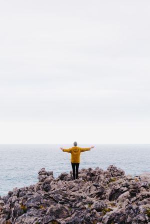Traveler in solitude walking on rocky shore