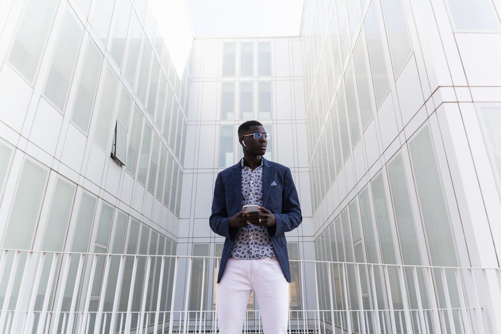 Black businessman listening to music in earbuds in city