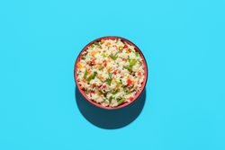 Fried rice bowl above view on a blue background