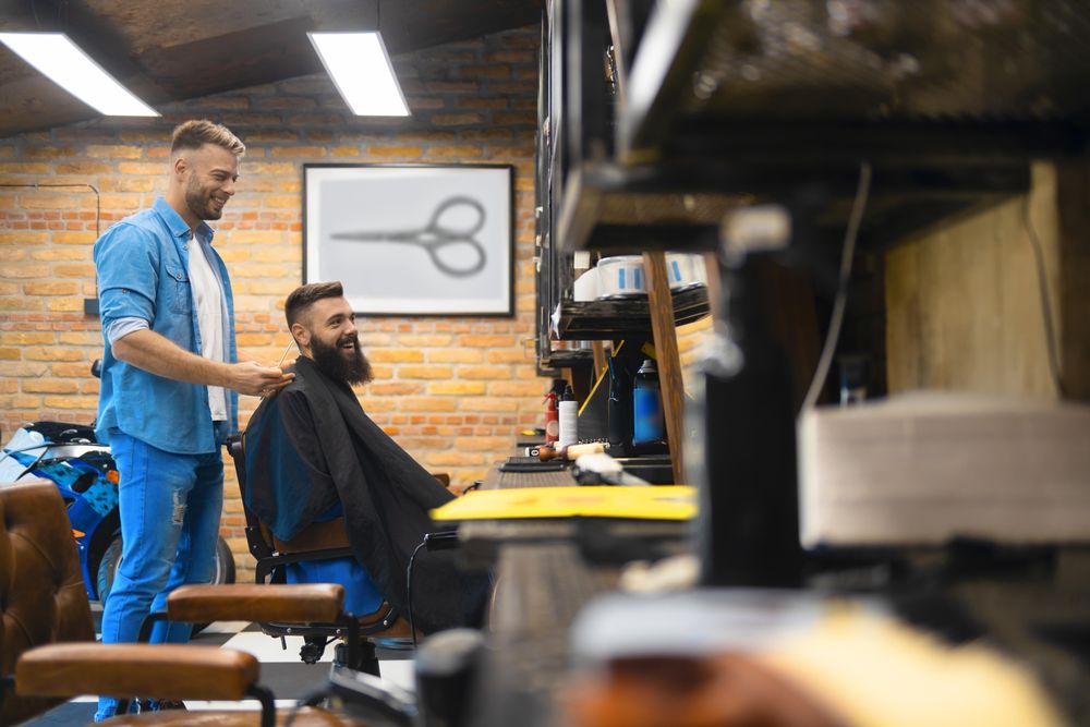 Barber and client smiling in the shop
