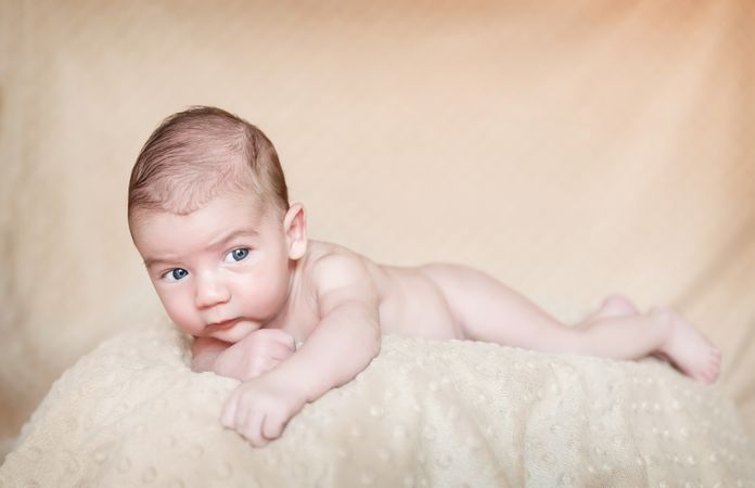 Portrait of newborn baby lying down over a blanket