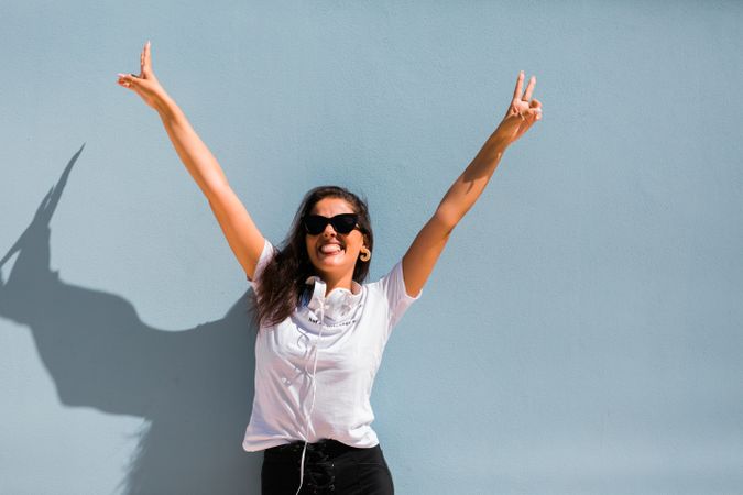 Cheerful casual woman in sunglasses standing on city street