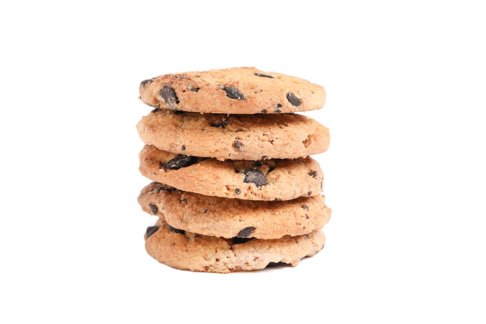 Stack of tasty chocolate chip cookies on blank background