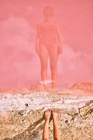 Fit woman in swimsuit posturing on pink lake shore