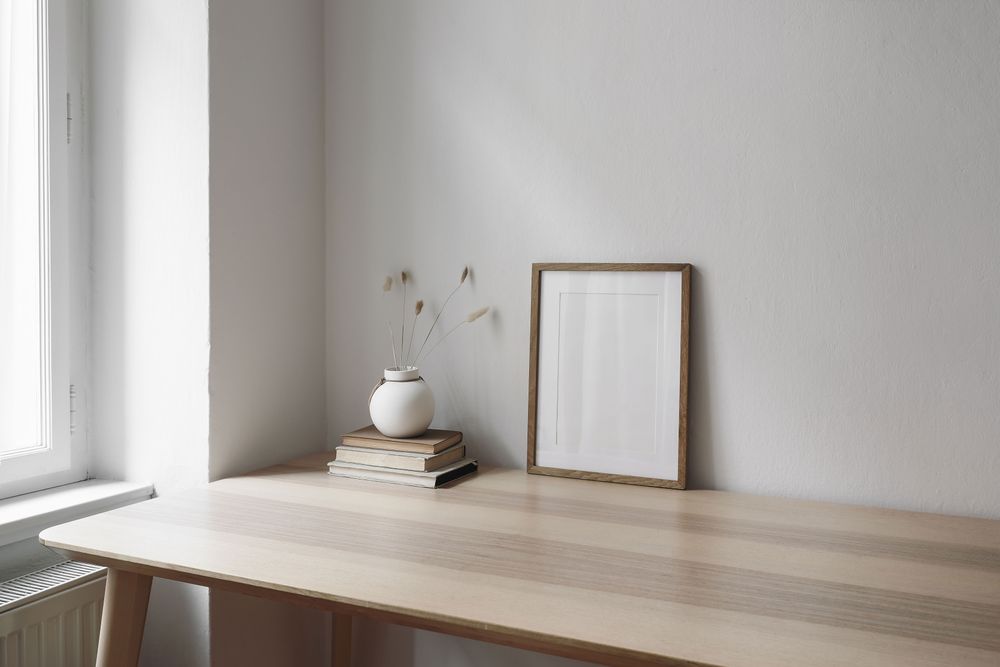Elegant living room with vertical wooden picture frame mockup on table near window