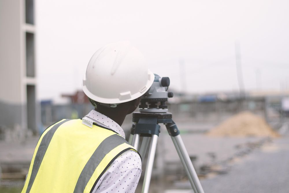Back view of man with bump hat looking through a telescope