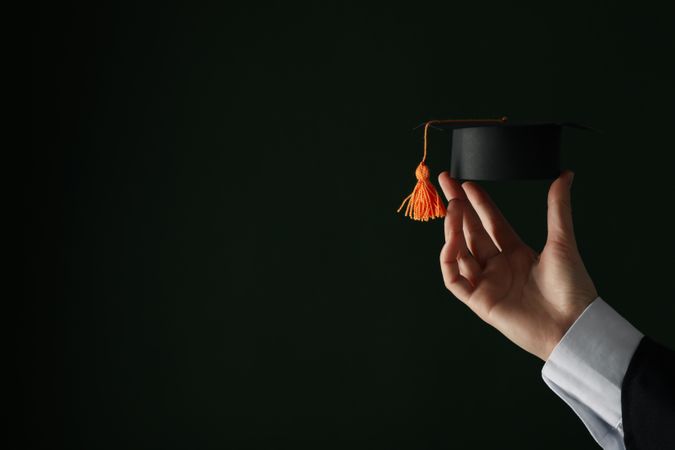 The hat of a university graduate, in his hands.