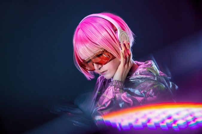 Trendy Asian woman listening music in headphones