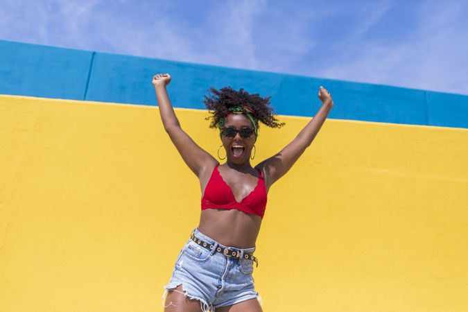 Joyous Black woman with arms up in excitement