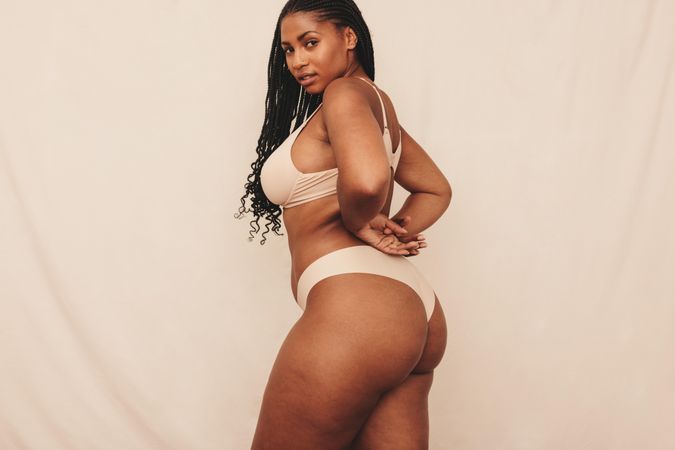 Body positive young woman looking at the camera while wearing beige underwear