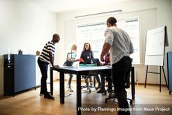 Group of people with miniature ping pong set in office 0ymqW0