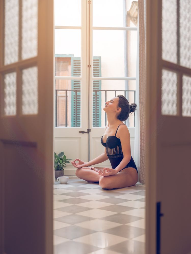 Woman in bodysuit meditating in lotus pose