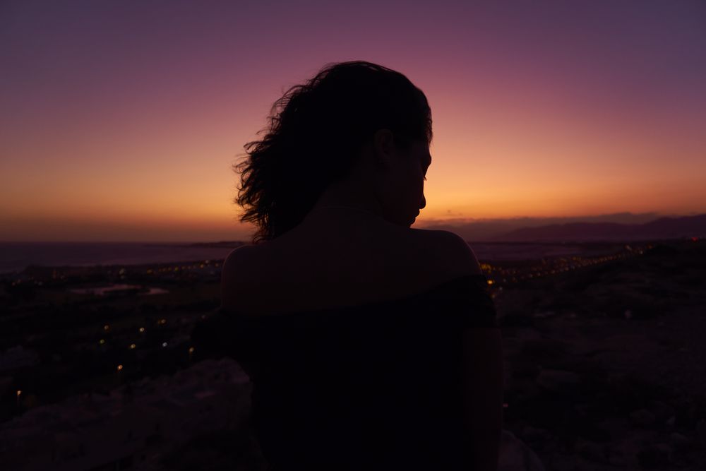 Silhouette of female enjoying picturesque sunset