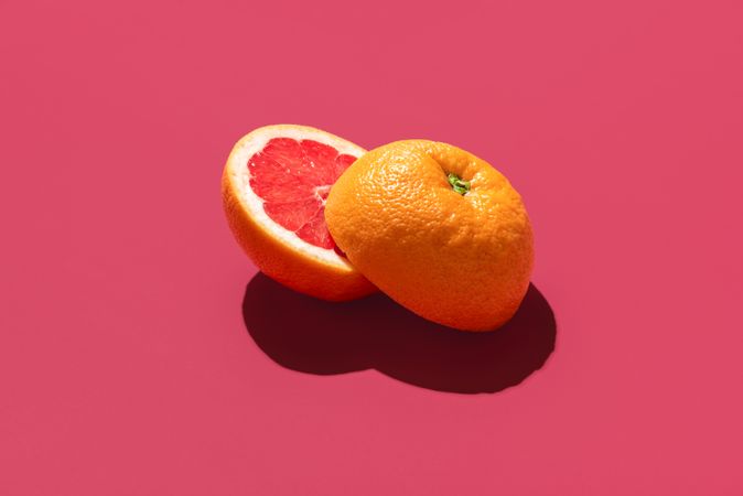 Grapefruit sliced in half, isolated on a magenta background
