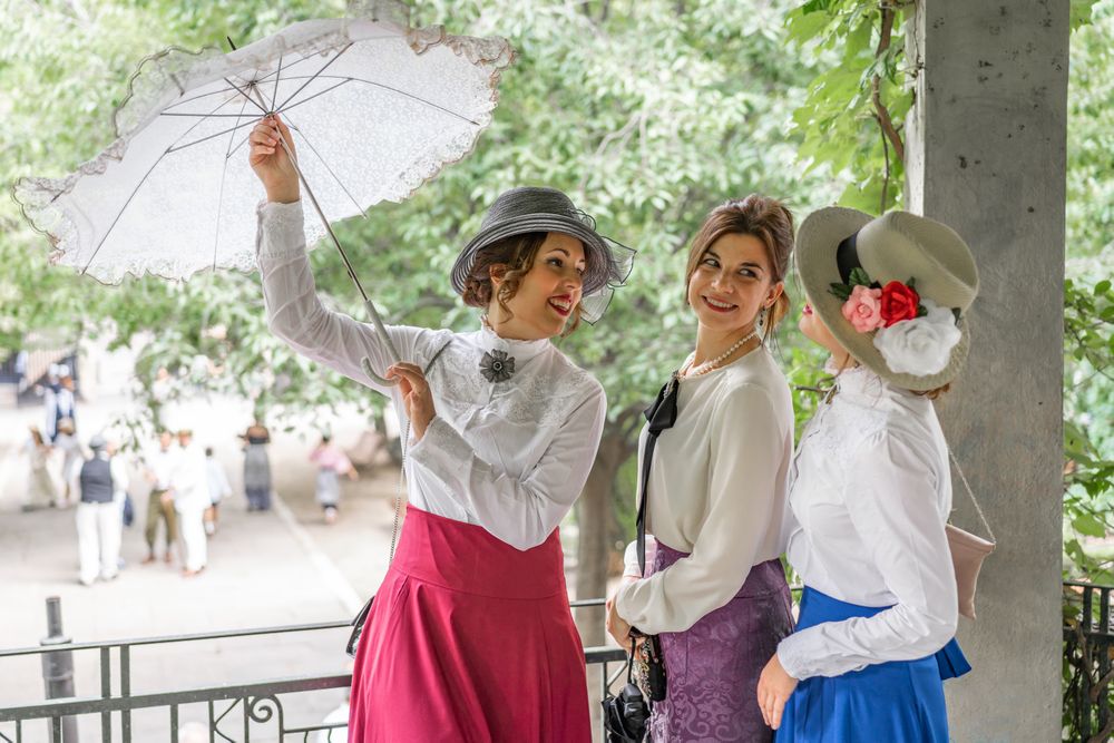 Vintage female opening parasol near friends