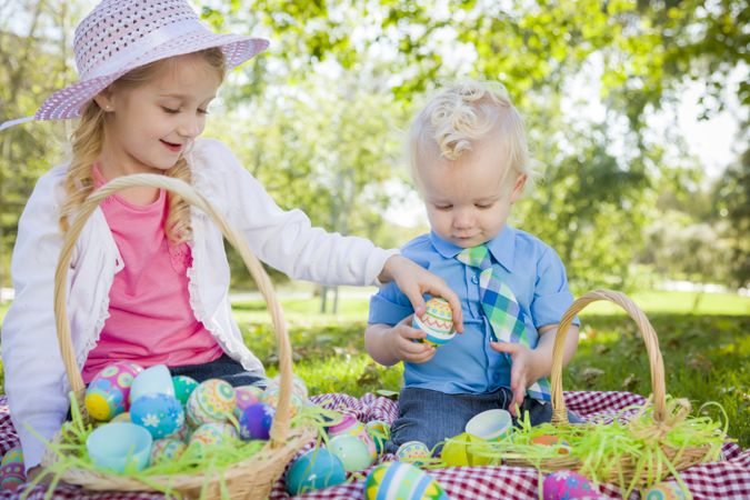 Cute Young Brother and Sister Enjoying Their Easter Eggs Outside