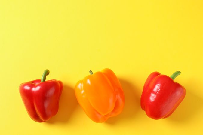 Bell peppers on yellow background, space for text