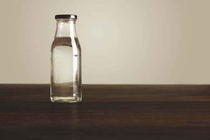 Glass bottle of water on wooden table