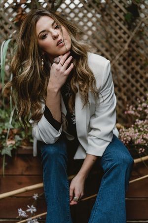 Woman sitting on planter in garden