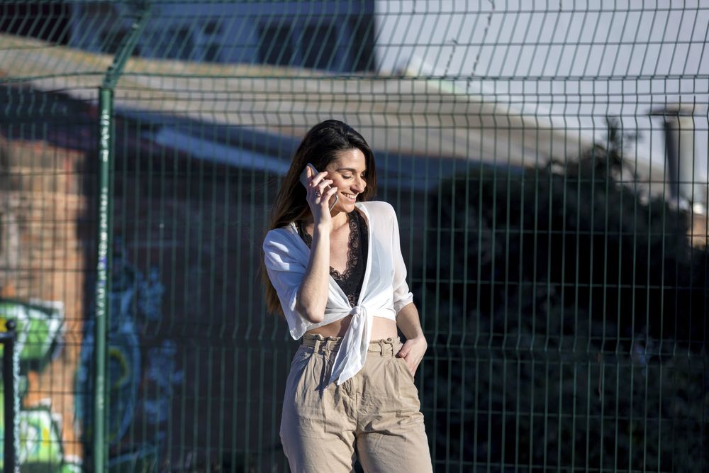 Young woman standing in the street while talking on a mobile phone