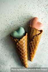 Two ceramic hearts in waffle cones on grey table with glitter 4MGGKk