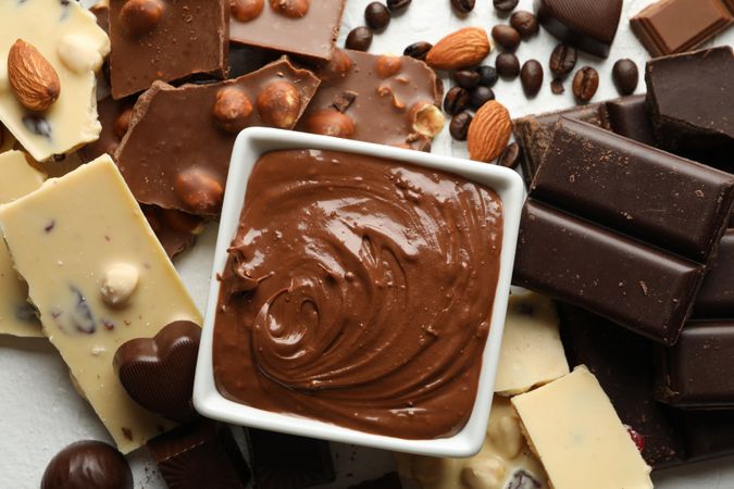Chocolate, melted chocolate, coffee and almond on blank background