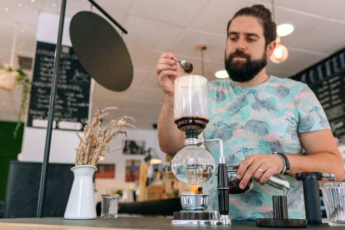 Barista skillfully preparing a specialty coffee in Japanese siphon coffee maker with precision