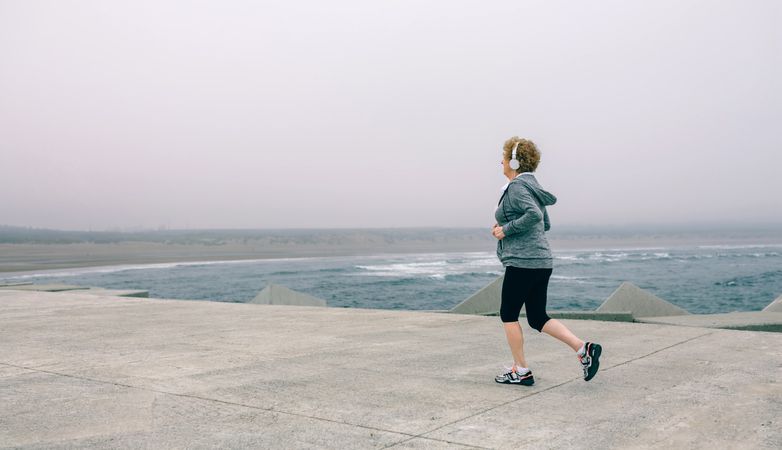 Older woman with headphones running