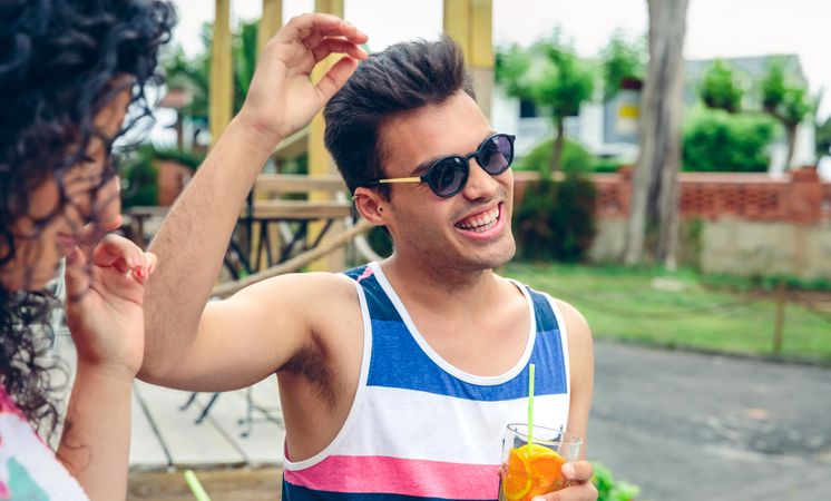 Young man enjoying cocktails with friends outside