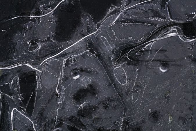 Fragment of thin ice on dark frozen river