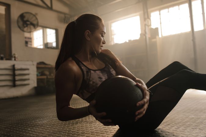Woman working out in gym using medicine bal