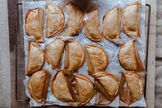 Baking tray with composed freshly baked pies patty