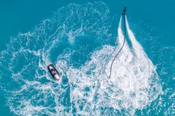 Overhead shot of person jet blading and another on a jet ski