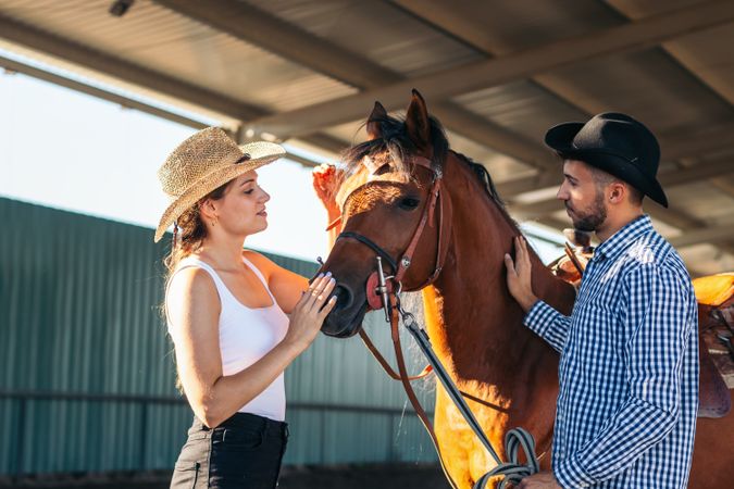 Friends walking with a horse in an equestrian center