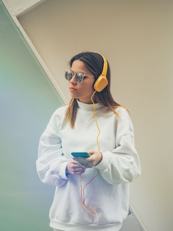 Trendy young woman with headphones and smartphone