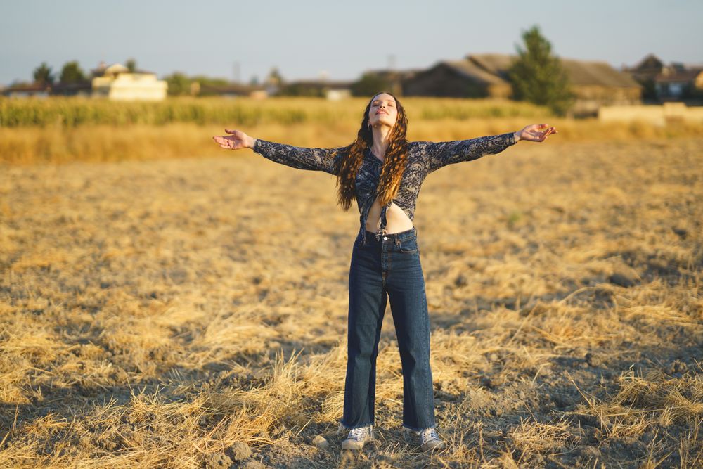 Embracing the feeling of freedom while surrounded by vibrant wildflowers in a sunlit field