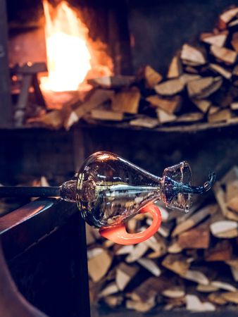 Glass vase near fire and firewood