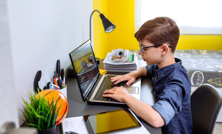 Boy doing homework with laptop