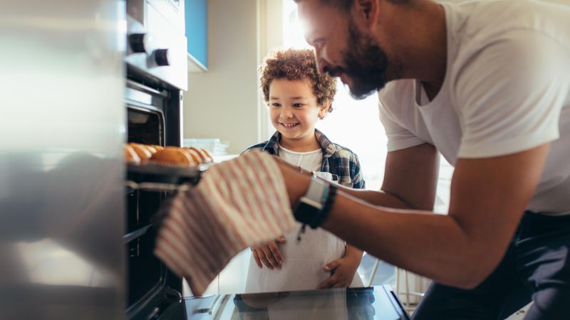 Father and son baking cookies at home